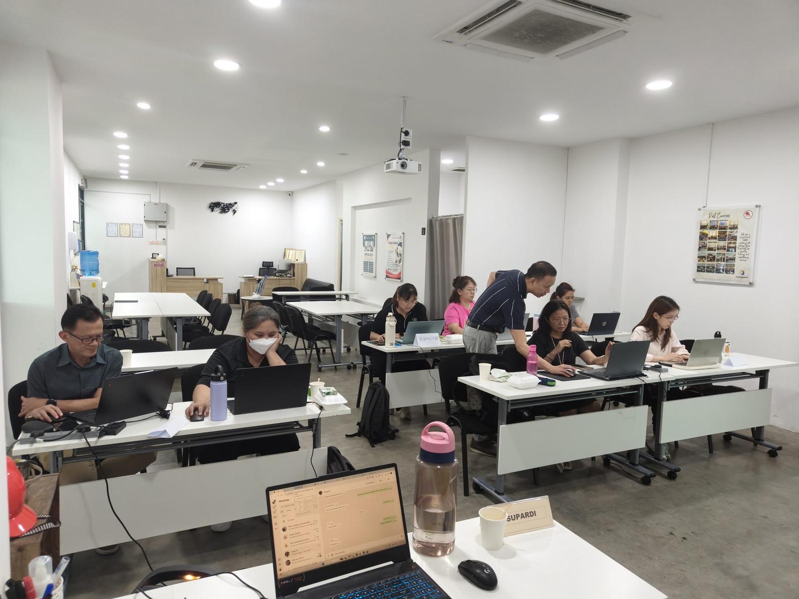 Participants working on laptops during a practical AI automation programme